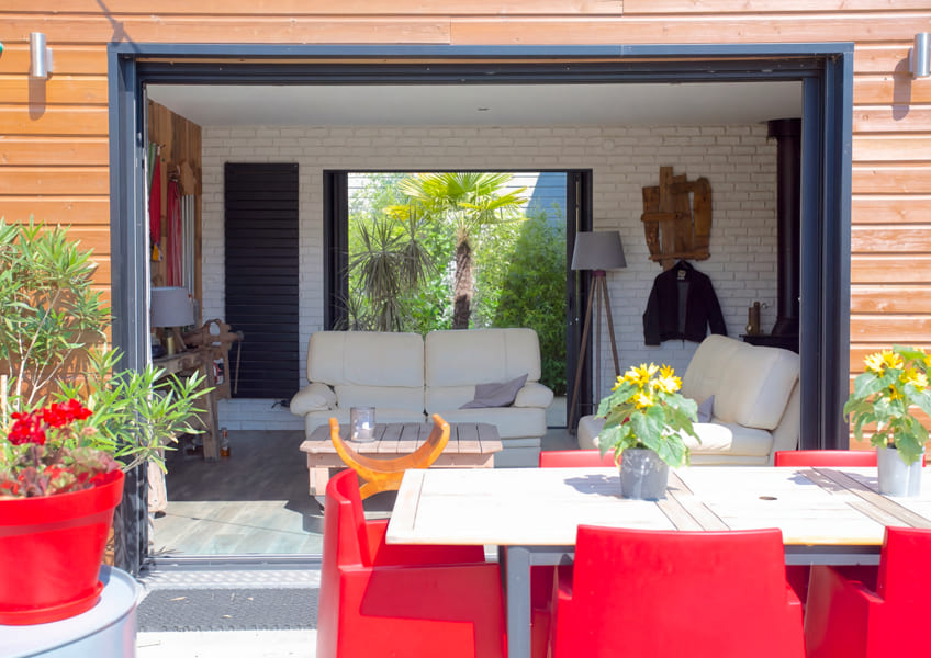 L'extension bois avec les chaises rouges en terrasse